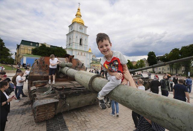 Children play on a destroyed Russian tank at a square in Kyiv on June 5, 2022. (Kyodo) ==Kyodo