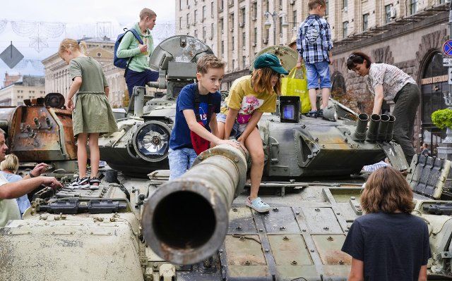 Children play on a destroyed Russian tank put on display in a square in Kyiv on Aug. 20, 2022. (Kyodo) ==Kyodo