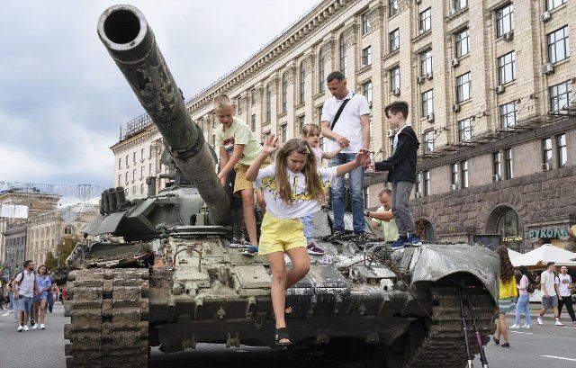 Children play on a destroyed Russian tank put on display in a square in Kyiv on Aug. 20, 2022. (Kyodo) ==Kyodo