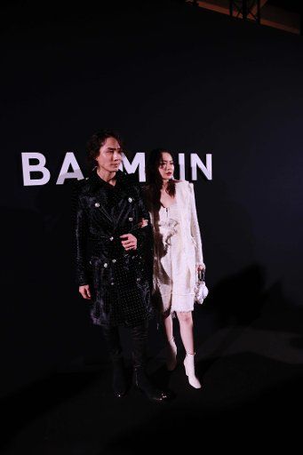 Chinese actress Stephy Qi (Qi Wei), right, and her South Korean singer husband Lee Seung Hyun attend the Balmain fashion show during the Paris Men\