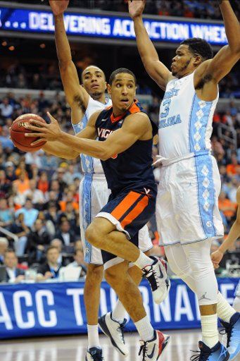 12 March 2016: Virginia Cavaliers guard Malcolm Brogdon (15) makes a pass under the basket against North Carolina Tar Heels forward Brice Johnson (11) and forward Kennedy Meeks (3) in the final of the ACC Tournament at the Verizon Center in ...