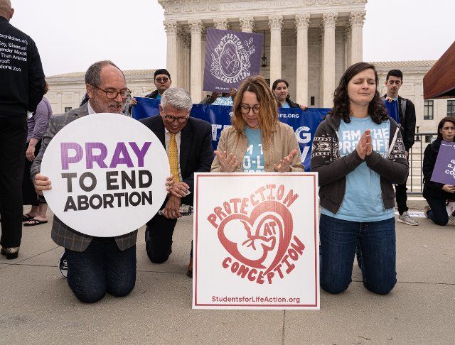Anti-abortion activists pray as demonstrators rallied in response to the news that the Supreme Court has drafted a majority opinion overturning Roe v. Wade which effectively would end the federal right to a safe and legal abortion in this country. In front of the Supreme Court Building in Washington D.C. on May 3, 2022. (Photo by Jeff Malet