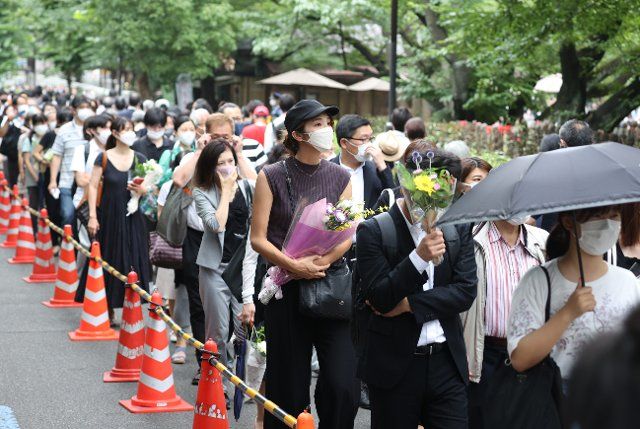 People offer flowers to the late former Prime Minister Shinzo Abe in Tokyo, Japan, Tuesday afternoon, July 12, 2022. A funeral for Abe, who was gunned down last week, took place among his relatives and other people close to him at the Zojoji temple in Tokyo on Tuesday. (Jiji Press\/Yuya Yamamoto