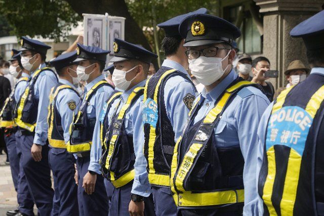 Police officers stand guard in front of demonstrators protesting against the state funeral for former Prime Minister Shinzo Abe near the venue in Tokyo, Japan, September 27, 2022. JIJI PRESS PHOTO \/ MORIO TAGA