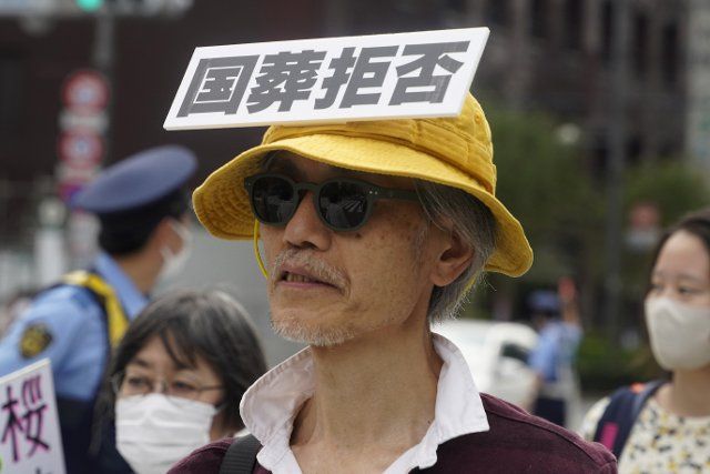 A participant holding placard marches to protest against the state funeral for former Japanese Prime Minister Shinzo Abe, which was held at the budokan in Tokyo, Japan, September 27, 2022. JIJI PRESS PHOTO \/ MORIO TAGA