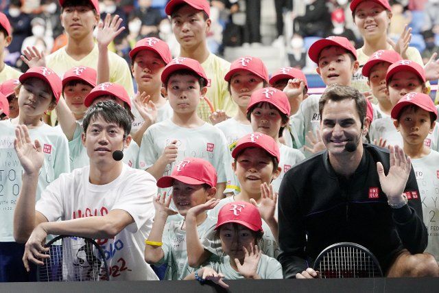Former tennis player Roger Federer of Switzerland (R) and tennis player Kei Nishikori attend a photo-call with school children at a promotional event for Japanese casual wear retailer Uniqlo in Tokyo, Japan, November 19, 2022. Federer, tennis legend, retired his professional competitive career in September 2022. JIJI PRESS PHOTO \/ MORIO TAGA