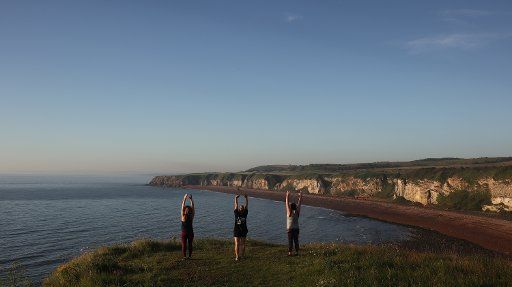 Seaham is a seaside town in County Durham, England, morning scenes, Friday 31st July 2020. Friends Michelle Hall, left, Michelle Cooper, centre and Sarah Batson, right doing yoga together in the dawn light at Nose\