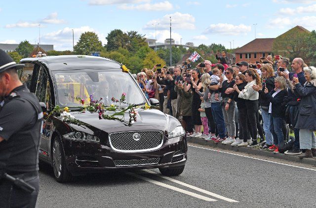 HM Queen Elizabeth II funeral procession. The hearse carrying the coffin, draped in the Royal Standard, passing near Egham, beside the Runnymede Pleasure Grounds, on it\