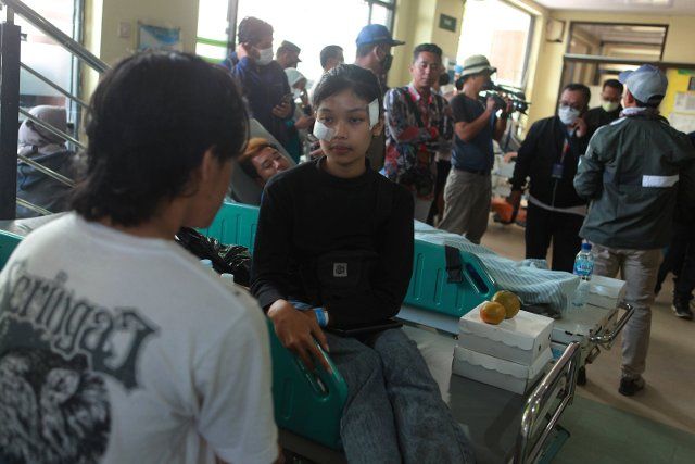 (221002) -- MALANG, Oct. 2, 2022 (Xinhua) -- Injured people receive medical treatment at a hospital in Malang of East Java province, Indonesia, Oct. 2, 2022. The death toll in a crowd stampede at a football match in Indonesia\