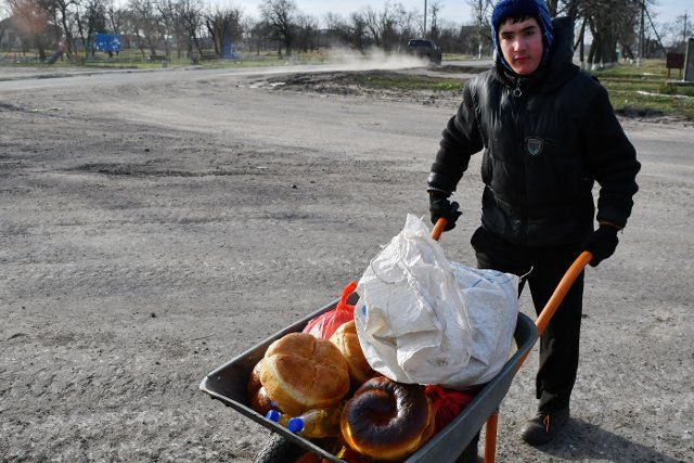 A man receives food on a construction wheelbarrow at a mobile humanitarian aid point in the village of Zarichne. Russia has fired a barrage of missiles at targets across Ukraine for the eighth time in eight weeks. Significant disruption to the power grid was reported, mainly in the east. Ukraine says four people were killed. (Photo by Andriy Andriyenko \/ SOPA Images\/Sipa USA