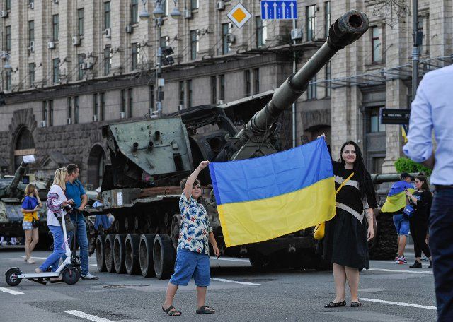 People take pictures with the Ukrainian flag near destroyed Russian army equipment displayed at Khreshchatyk in the center of Kyiv. As dedicated to the upcoming Independence Day of Ukraine, and nearly 6 months after the full-scale invasion of Ukraine on February 24, the country\