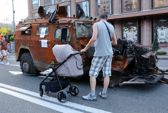 A man with a child in a stroller observes a destroyed Russian army, equipment exhibited on Khreshchatyk in the center of Kyiv. As dedicated to the upcoming Independence Day of Ukraine, and nearly 6 months after the full-scale invasion of Ukraine on February 24, the country\