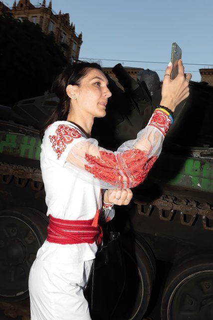 A woman wearing a national Ukrainian costume vyshyvanka takes a selfie against the backdrop of a burned-out Russian tank. An exhibition of destroyed Russian equipment is being organized at Khreshchatyk. Six months ago, Russian military troops were deployed by Russian president Vladimir Putin to invade Ukraine. He reportedly reckoned that they would capture Kyiv in three days, (Photo by Mykhaylo Palinchak \/ SOPA Images\/Sipa USA