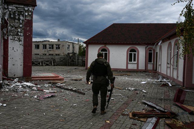 A Ukrainian service member walks past destroyed buildings destroyed and damaged by fighting in the village of Drobysheve on October 5, 2022. The village of Drobysheve was liberated by the Ukrainian Armed Forces in September during a successful counter offensive in the Kharkiv and Donetsk regions of Ukriane, and was used as a staging point for the successful counterattack into the strategic city of Lyman from September 17, 2022 until October 1, 2022. Drobysheve, Ukraine. Russian military forces entered Ukraine territory on Feb. 24, 2022. (Photo by Justin Yau\/ Sipa USA