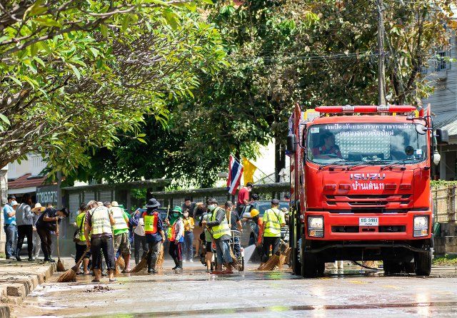 Municipal workers clean up a road in Chiang Mai\