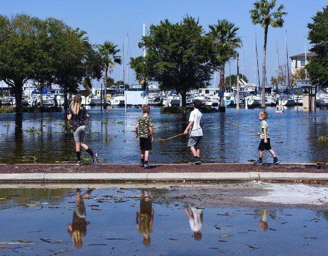 Children play in a flooded parking lot near the Sanford Riverwalk as the St. Johns River reaches major flood stage, causing Lake Monroe to breach the sea wall in the aftermath of Hurricane Ian in downtown Sanford. The St. Johns river is expected crest tonight before slowly receding. (Photo by Paul Hennessy \/ SOPA Images\/Sipa USA