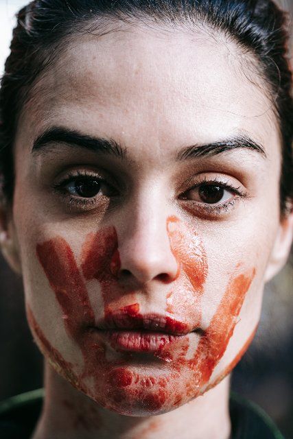 A woman paints a bloody handprint on her face during the demonstration. Thousands march to United Nations headquarters to commemorate Bloody November of 2019, when Iran\