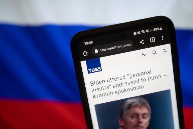 In this photo illustration a Tass Agency logo seen displayed on a smartphone with a Russian flag in the background. (Photo by Mateusz Slodkowski \/ SOPA Images\/Sipa USA