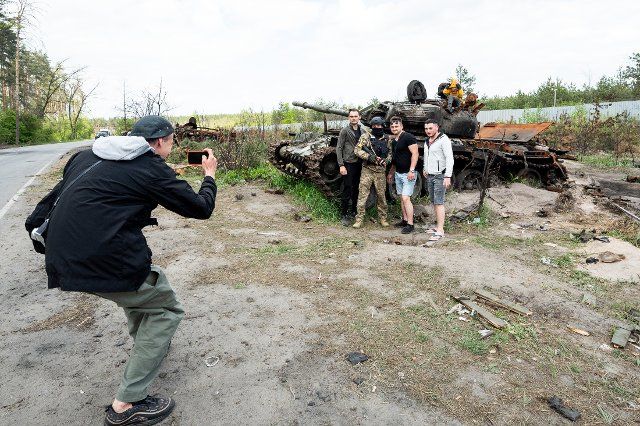 People being photographed in front of a destroyed RUssian tank. (Photo by Michael Brochstein\/Sipa USA