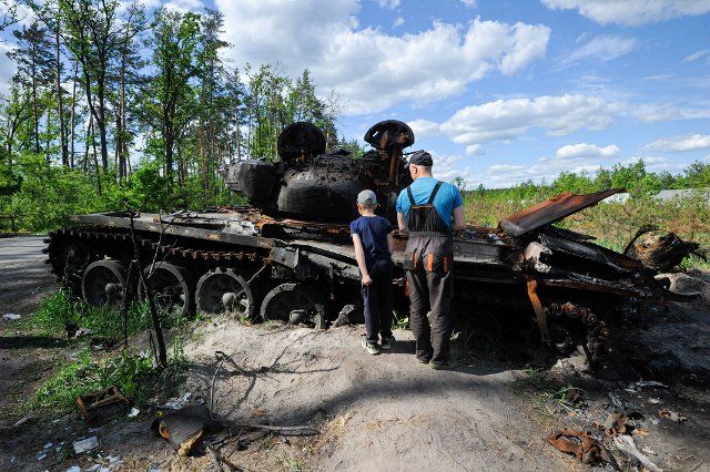 A man and a young boy look at a destroyed Russian military equipment at Dmytrivka village near the Ukrainian capital Kyiv. Russia invaded Ukraine on 24 February 2022, triggering the largest military attack in Europe since World War II. (Photo by Sergei Chuzavkov \/ SOPA Images\/Sipa USA