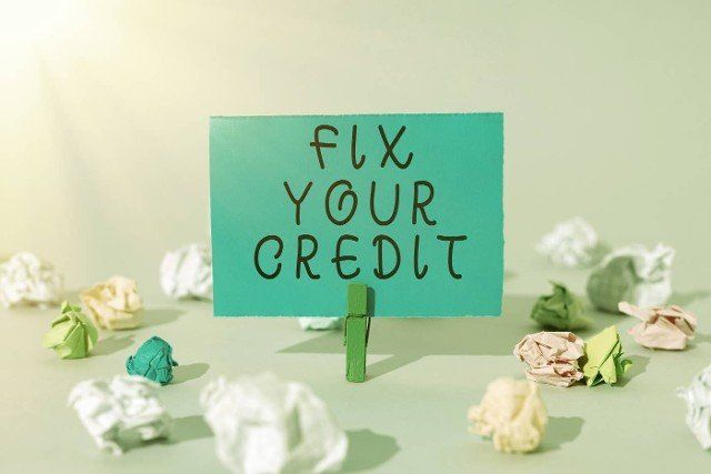 Text caption presenting Fix Your Credit,  Concept meaning Keep balances low on credit cards and other credit Important Message Presented On Piece Of Paper Clipped With Clip.
