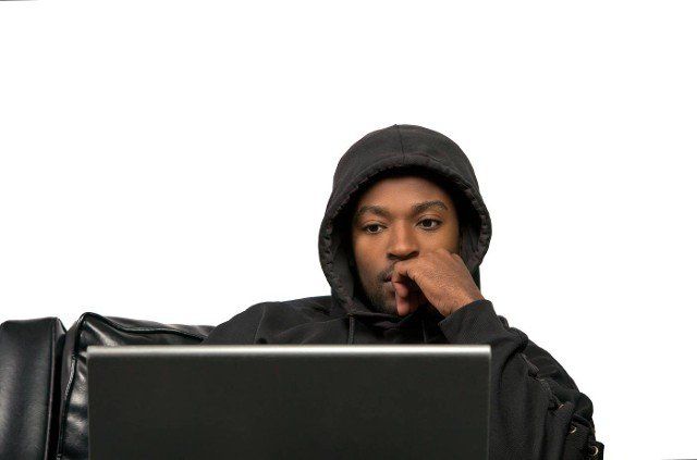 young man using laptop computer black sofa wearing hoody on white isolated background