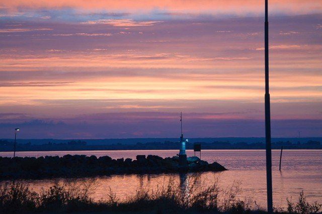 Sunset in Sweden at the harbor of lake Vaettern. Lighthouse in the background at dusk. Landscape shot in Scandinavia.