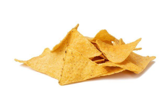 pile of corn tortilla chips or nachos isolated on a white background,  close up