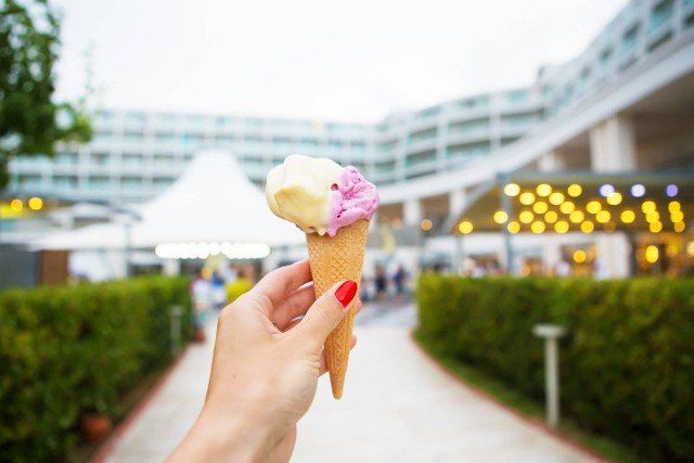 bright ice cream in the hands of a beautiful hotel
