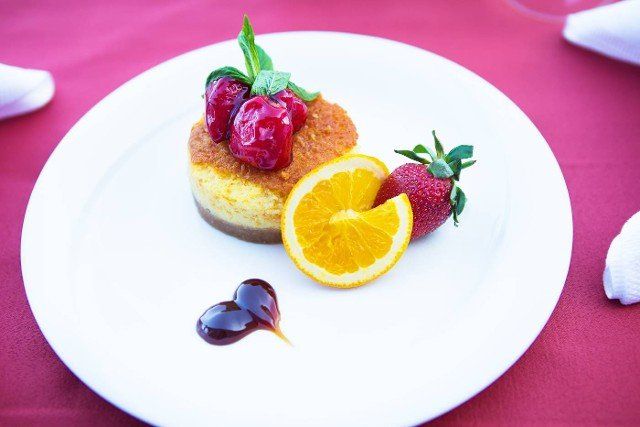 cake-cheesecake decorated with strawberries and orange lies on a white plate