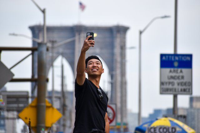 Tourists are coming back to New York City. A tourist is seen taking selfie infront of Brooklyn Bridge in New York City on April 13, 2022. (Photo by Ryan Rahman\/Pacific Press