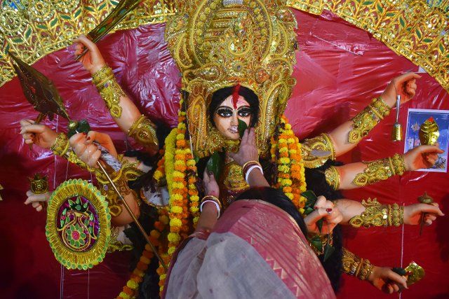 A woman performs a ritual with banana leaves to an idol of the Hindu goddess Durga while offering prayers on the last day of the Durga Puja festival in Kolkata. (Photo by Sudipta Das \/ Pacific Press