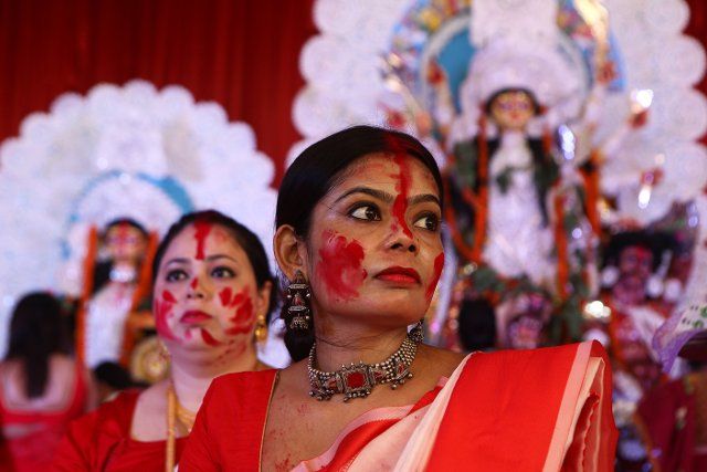 women faces covered with Vermilion sitting in front of Godess Durga Idol on the last day of Durga Puja festival in New Delhi on 5th October 2022. Women Play with Vermilion on the last day of Durga Puja Festival (Photo by Ranjan Basu\/Pacific Press