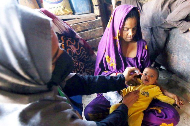 KARACHI, PAKISTAN, DEC 06: Health worker administrates polio-vaccine drops to a child during anti-polio immunization campaign, located on Gharibabad area in Karachi on Tuesday, December 06, 2022. (S.Imran Ali\/PPI Images