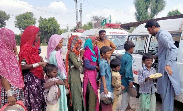 HYDERABAD, PAKISTAN, SEP 11: Volunteers are distribute relief foods among flood affected people after submerged flood in area due to recent heavy downpour of monsoon season, in Hyderabad on Sunday, September 11, 2022. (Sajjad Zaidi\/PPI Images