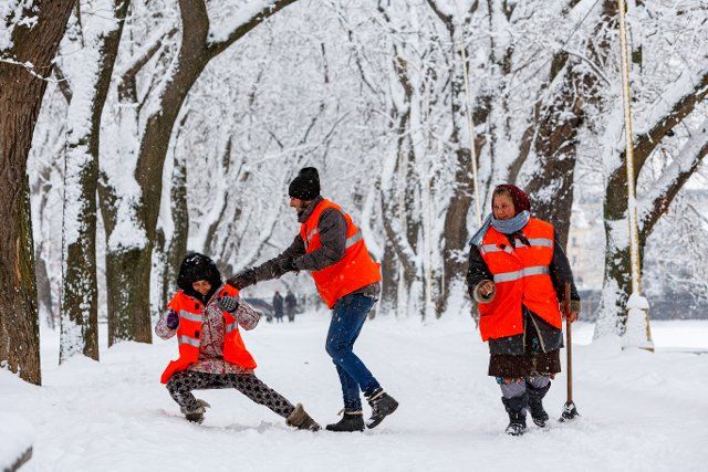 UZHHOROD, UKRAINE - FEBRUARY 2, 2022 - Municipal service workers have fun during a snow removal effort in winter, Uzhhorod, Zakarpattia Region, western Ukraine., Credit:Serhii Hudak \/ Avalon