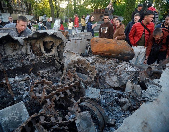 VINNYTSIA, UKRAINE - MAY 5, 2022 - People look at a Russian tank and an APC destroyed in heavy fighting near Bucha and Irpin, Kyiv Region, that are put on display as a show of defiance and a reminder that the war is near in Yevropeiska Square, 