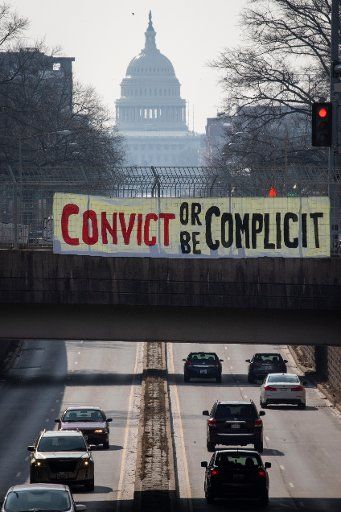 UNITED STATES - February 10: A banner that reads âconvict or be complicitâ hangs over a bridge on North Capitol Street on the second day of former President Donald Trump\