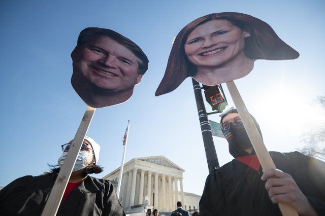 UNITED STATES - DECEMBER 1: Reproductive rights activists hold cut out photos of Justices Brett Kavanaugh and Amy Coney Barrett as oral arguments in Dobbs v. Jackson WomenÃs Health Organization case are held on Wednesday, December 1, 2021. The case considers the constitutionality of MississippiÃs restrictive ban on abortion after 15 weeks. (Photo by Bill Clark\/CQ Roll Call