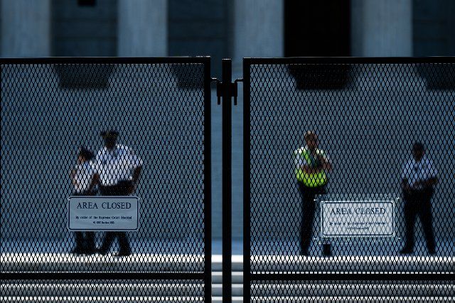 UNITED STATES - MAY 23: Supreme Court of the United States Police stand guard on the plaza of the U.S. Supreme Court building behind the riot fencing on Monday, May 23, 2022. Security precautions are elevated in anticipation of the court overturning Roe v Wade. (Bill Clark\/CQ Roll Call