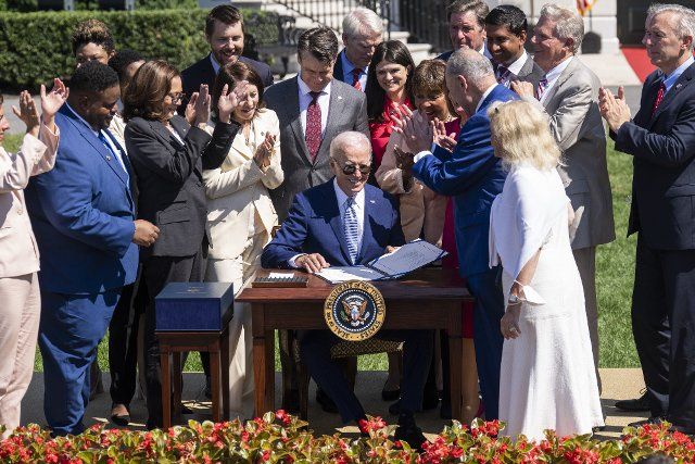 UNITED STATES - AUGUST 9: President Joe Biden signs the The CHIPS and Science Act of 2022 on the South Lawn of the White House, which provides funding for the semiconductor industry, on Tuesday, August 9, 2022. Vice President Kamala Harris, Sens. Maria Cantwell , D-Wash., Todd Young, R-Ind., Rob Portman, R-Ohio, Reps. Haley Stevens, D-Mich., Eddie Bernice Johnson, D-Texas, John Garamendi, D-Calif., Ro Khanna, D-Calif., Frank Pallone, D-N.J., John Katko, R-N.Y., Speaker of the House Nancy Pelosi, D-Calif., Senate Majority Leader Charles Schumer, D-N.Y., and Debbie Dingell, D-Mich., are also pictured. (Tom Williams\/CQ Roll Call