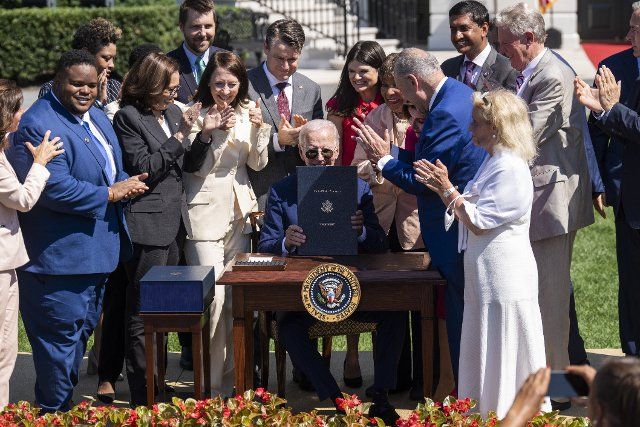 UNITED STATES - AUGUST 9: President Joe Biden signs the The CHIPS and Science Act of 2022 on the South Lawn of the White House, which provides funding for the semiconductor industry, on Tuesday, August 9, 2022. Vice President Kamala Harris, Sens. Maria Cantwell , D-Wash., Todd Young, R-Ind., Rob Portman, R-Ohio, Reps. Haley Stevens, D-Mich., Eddie Bernice Johnson, D-Texas, John Garamendi, D-Calif., Ro Khanna, D-Calif., Frank Pallone, D-N.J., John Katko, R-N.Y., Speaker of the House Nancy Pelosi, D-Calif., Senate Majority Leader Charles Schumer, D-N.Y., and Debbie Dingell, D-Mich., are also pictured. (Tom Williams\/CQ Roll Call