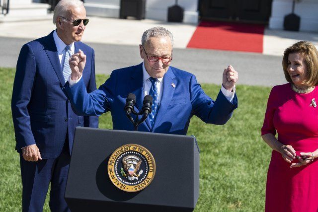 UNITED STATES - AUGUST 9: Senate Majority Leader Charles Schumer, D-N.Y., President Joe Biden, and Speaker of the House Nancy Pelosi, D-Calif., are seen during The CHIPS and Science Act of 2022 bill signing on the South Lawn of the White House, which provides funding for the semiconductor industry, on Tuesday, August 9, 2022. (Tom Williams\/CQ Roll Call