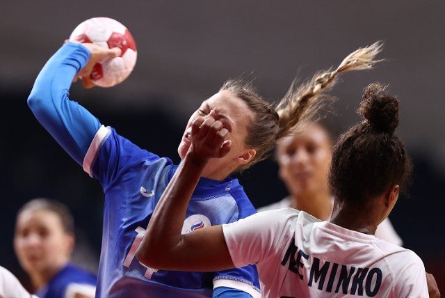 TOKYO, JAPAN - AUGUST 8, 2021: Players Polina Vedekhina (L) of ROC and Estelle Nze Minko of France struggle in the womenâs final handball match between ROC and France at the Yoyogi National Gymnasium as part of the 2020 Summer Olympic Games. 