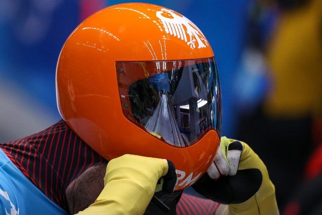 BEIJING, CHINA - FEBRUARY 11, 2022: Yin Zheng of China takes off a helmet after competing in the men\