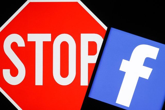 NOVOSIBIRSK, RUSSIA â MARCH 11, 2022: Pictured in this photo illustration is the logo of the Facebook social networking service and a stop sign. The Russian Federal Service for Supervision of Communications, Information Technology and Mass Media 
