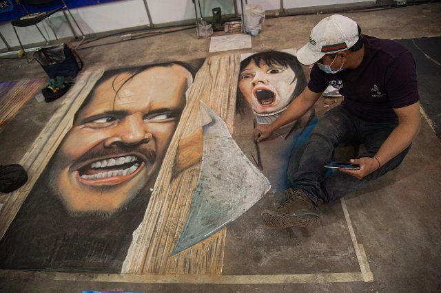 Artists make murals referencing movies and comics on the ground during the fourth day of the SOFA (Salon del Ocio y la Fantasia) 2021, a fair aimed to the geek audience in Colombia that mixes Cosplay, gaming, superhero and movie fans from across 