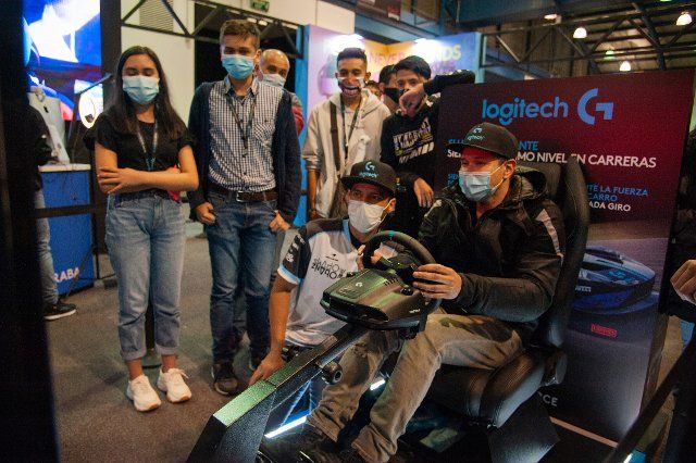 People play and enjoy a driving simulator from Logitech during the fourth day of the SOFA (Salon del Ocio y la Fantasia) 2021, a fair aimed to the geek audience in Colombia that mixes Cosplay, gaming, superhero and movie fans from across Colombia, 