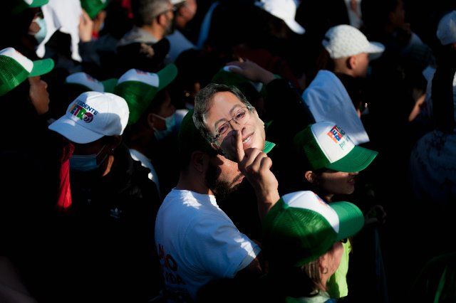 A supporter covers from the sun with a cut-out face of candidate Gustavo Petro during the closing campaign rally of left-wing presidential candidate for the political alliance \