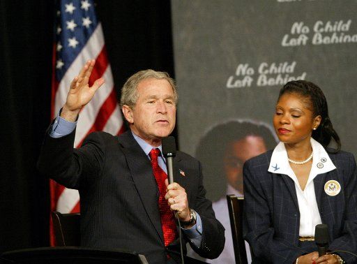 President George Bush makes a point as Pierre Laclede Elementary School principal Yolanda Moss looks on during a visit in St. Louis on January 5 2004. Bush held a panel discussion with teachers and parents on the No Child Left Behind Act.  (UPI...